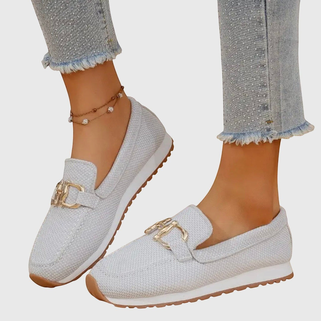 Nora & Elise Susie light grey orthopaedic moccasin trainers with gold horseshoe detail and white sole.