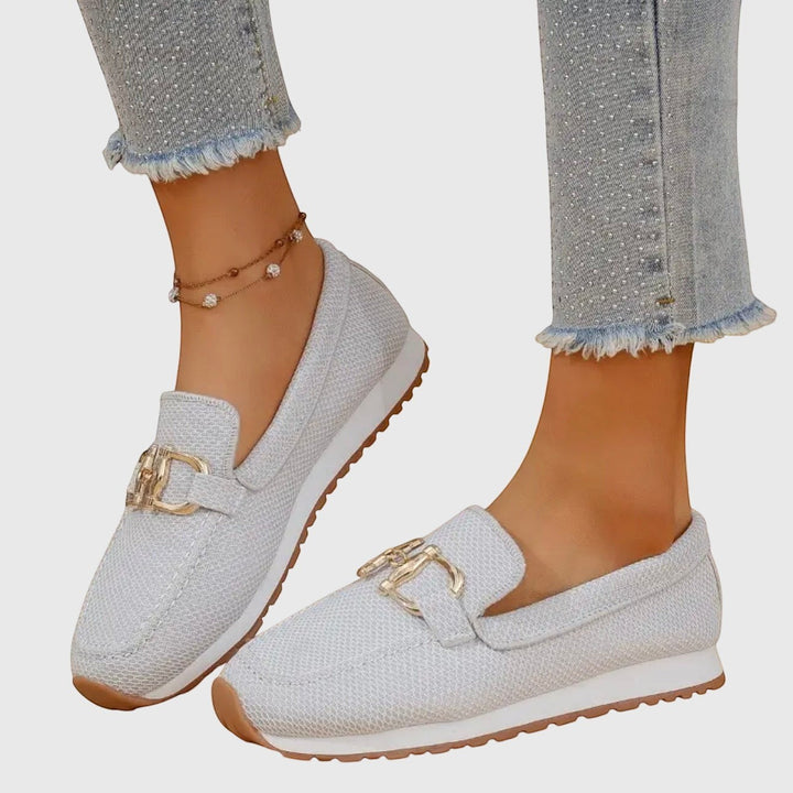 Nora & Elise Susie light grey orthopaedic moccasin trainers with gold horseshoe detail and white sole.