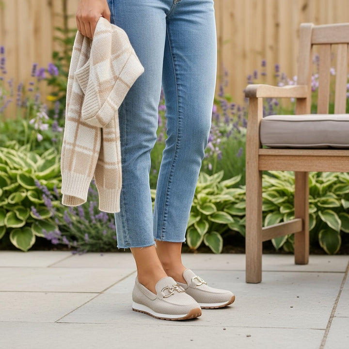 Nora & Elise Susie light beige orthopaedic moccasin trainers with gold horseshoe detail and non-slip sole.